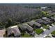 A scenic aerial view shows this property with lush landscaping, a wooded area, and neighboring houses at 400 Indian Wells Ave, Poinciana, FL 34759