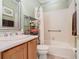 Bright bathroom with wood vanity, framed mirror, decorative shower curtain and a tub at 400 Indian Wells Ave, Poinciana, FL 34759