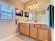 Bathroom featuring a vanity with blonde wood cabinets, large mirror and tiled floor at 400 Indian Wells Ave, Poinciana, FL 34759