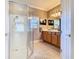 Bright bathroom boasts a glass enclosed shower, blonde wood vanity, and decorative tile floor at 400 Indian Wells Ave, Poinciana, FL 34759