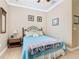 Cozy bedroom with blue quilt, decorative wall art, and traditional crown molding at 400 Indian Wells Ave, Poinciana, FL 34759