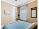 Bedroom featuring a blue quilt, side table with lamp, and sheer window coverings at 400 Indian Wells Ave, Poinciana, FL 34759