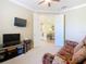 Comfortable den features neutral walls, plush carpet, ceiling fan, and double doors at 400 Indian Wells Ave, Poinciana, FL 34759
