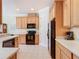 Well-equipped kitchen featuring tile floors, wood cabinets, modern appliances, and ample counter space at 400 Indian Wells Ave, Poinciana, FL 34759