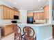 Spacious kitchen with light wood cabinets, granite countertops, black appliances, and breakfast bar with chairs at 400 Indian Wells Ave, Poinciana, FL 34759