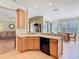 Bright kitchen with tile flooring, wood cabinets, and a breakfast bar overlooking the adjacent living room and dining area at 400 Indian Wells Ave, Poinciana, FL 34759