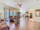 Spacious living room with wood flooring, large windows, and an open layout to the kitchen and dining areas at 400 Indian Wells Ave, Poinciana, FL 34759