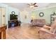 Cozy living room with wood floors, a ceiling fan, and a comfortable seating arrangement at 400 Indian Wells Ave, Poinciana, FL 34759