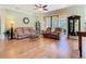 Bright living room featuring wood floors, a ceiling fan, and sliding glass doors to the outdoor patio at 400 Indian Wells Ave, Poinciana, FL 34759