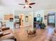 Open-concept living room with wood floors, neutral walls, and a seamless flow to the kitchen area at 400 Indian Wells Ave, Poinciana, FL 34759