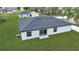 Back exterior of a one story white house with gray roof surrounded by green lawn with trees at 41 Peterlee Ct, Kissimmee, FL 34758