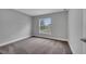 Bedroom with a large window offering natural light and views, complemented by neutral gray walls and soft carpet at 41 Peterlee Ct, Kissimmee, FL 34758