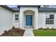 Close-up of a blue front door with decorative plants in front at 41 Peterlee Ct, Kissimmee, FL 34758