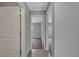 Hallway showcases open doorways to carpeted bedrooms, featuring a tile floor and neutral gray walls at 41 Peterlee Ct, Kissimmee, FL 34758