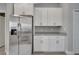 Kitchen with stainless steel refrigerator, granite countertops, and white cabinetry at 41 Peterlee Ct, Kissimmee, FL 34758