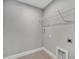 Neutral laundry area with tile floor, utility connections, and wire shelving for storage at 41 Peterlee Ct, Kissimmee, FL 34758