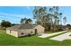 An elevated view of a home with a lush lawn and a long driveway leading to the garage at 43 Peterlee Ct, Kissimmee, FL 34758