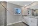 Bright bathroom featuring double sinks, granite countertops, and tiled shower at 43 Peterlee Ct, Kissimmee, FL 34758