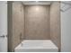 Clean, white bathtub with a tiled surround and chrome fixtures in a neutral bathroom at 43 Peterlee Ct, Kissimmee, FL 34758