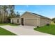 A sunny home with an attached two-car garage and long concrete driveway at 43 Peterlee Ct, Kissimmee, FL 34758