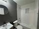 Modern bathroom with sleek vanity, toilet, and bathtub featuring stylish white tile and contrasting gray wall at 430 Connecticut Ave, St Cloud, FL 34769