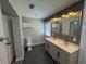 Well-lit bathroom with a double sink vanity, marble accents, and a separate toilet room at 430 Connecticut Ave, St Cloud, FL 34769