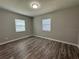 This bedroom features wood flooring, neutral paint, and natural light from the two windows at 430 Connecticut Ave, St Cloud, FL 34769