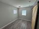 Neutral bedroom with wood-look flooring, natural light from windows, and a sliding barn door at 430 Connecticut Ave, St Cloud, FL 34769
