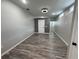 Neutral living room with wood-look flooring, multiple windows, a white door and a gray accent wall at 430 Connecticut Ave, St Cloud, FL 34769