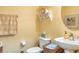 Half bath featuring yellow walls, a pedestal sink, and wicker basket at 4925 Poolside, St Cloud, FL 34769