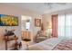 A cozy bedroom features a comfortable chair, decorative lamps, and a doorway to an en-suite bathroom at 4925 Poolside, St Cloud, FL 34769