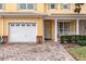 Townhome featuring a two-car garage, and inviting front door at 4925 Poolside, St Cloud, FL 34769