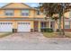 Charming townhome featuring a brick driveway, two-car garage, and inviting front porch with white columns at 4925 Poolside, St Cloud, FL 34769