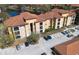 Aerial view showcasing the community's multiple buildings, a serene pond, and ample parking spaces at 6153 Metrowest Blvd # 103, Orlando, FL 32835