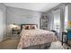 Neutral bedroom with a cozy bed, string lights, shelves, and a window view at 6153 Metrowest Blvd # 103, Orlando, FL 32835