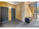 Condo entrance with two gray doors, stairs, and seating area at 6153 Metrowest Blvd # 103, Orlando, FL 32835