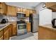 Efficient kitchen with stainless steel appliances, wooden cabinets, and tile backsplash at 6153 Metrowest Blvd # 103, Orlando, FL 32835