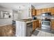 Efficient kitchen with stainless steel appliances, wooden cabinets, and tile backsplash at 6153 Metrowest Blvd # 103, Orlando, FL 32835