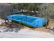 Aerial shot of a bright blue tennis court surrounded by lush landscaping and a secure black fence at 6153 Metrowest Blvd # 103, Orlando, FL 32835