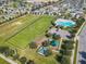 Aerial view of community park featuring sports field, playground, and community pool at 649 Meadow Pointe Dr, Haines City, FL 33844