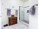 Bathroom featuring a glass shower, wood dresser, and light colored tile floors at 649 Meadow Pointe Dr, Haines City, FL 33844