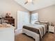 Tan bedroom featuring a ceiling fan, white dresser, bedside table and built-in closet at 649 Meadow Pointe Dr, Haines City, FL 33844