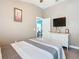 Tan bedroom featuring a large window, white dresser with TV, and open closet into blue office at 649 Meadow Pointe Dr, Haines City, FL 33844
