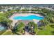 Large community pool surrounded by palm trees, gazebos, and lounge chairs at 649 Meadow Pointe Dr, Haines City, FL 33844