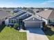 Front exterior view of a well-manicured home with a gray exterior and two-car garage at 649 Meadow Pointe Dr, Haines City, FL 33844