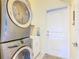 Bright laundry room featuring stacked washer and dryer units and a utility sink at 649 Meadow Pointe Dr, Haines City, FL 33844