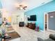 Cozy living room with a ceiling fan, turquoise accent wall, and view into other rooms at 649 Meadow Pointe Dr, Haines City, FL 33844