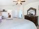 The main bedroom has a large bed, dresser, and dual access to ensuite bathrooms at 649 Meadow Pointe Dr, Haines City, FL 33844