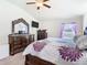 Spacious main bedroom with a large dresser, television, and a ceiling fan at 649 Meadow Pointe Dr, Haines City, FL 33844