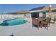 Beautiful backyard pool area with a dining table, lounge chairs, and well-maintained concrete at 649 Meadow Pointe Dr, Haines City, FL 33844
